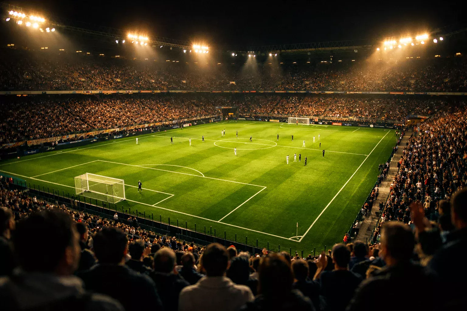 Stadio di calcio italiano illuminato durante una partita serale con riflettori accesi